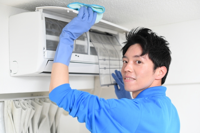 エアコンを掃除する清掃業者の若い男性